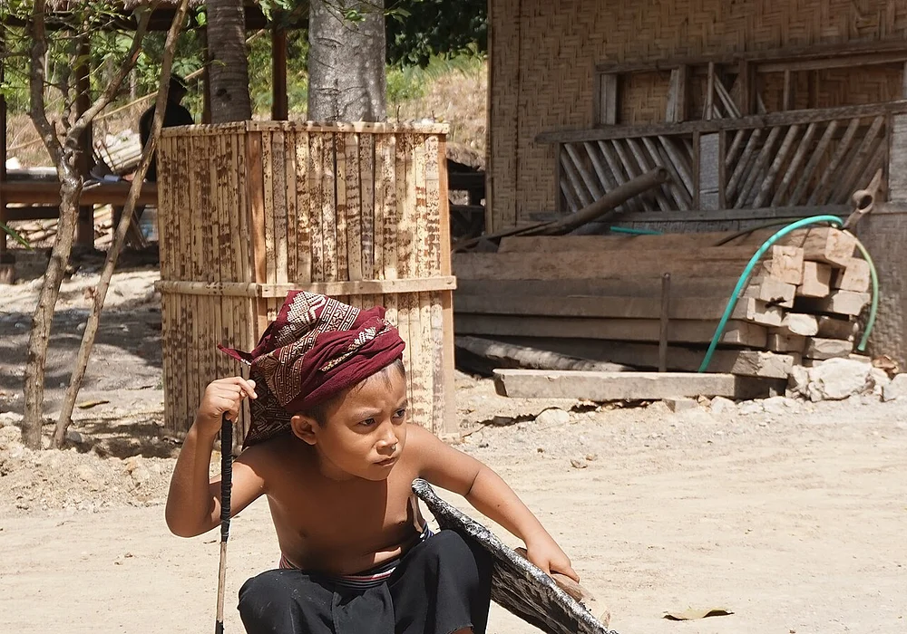 A Sasaknese boy is watching his contender in the Prisean game in Sasaknese Ende Village in Lombok. Prisean is the traditional fighting match with wooden stick and shield, transforming from bloody shows into interesting martial arts for tourists. For Sasaknese man, fighting spirit has been growing even since boyhood.